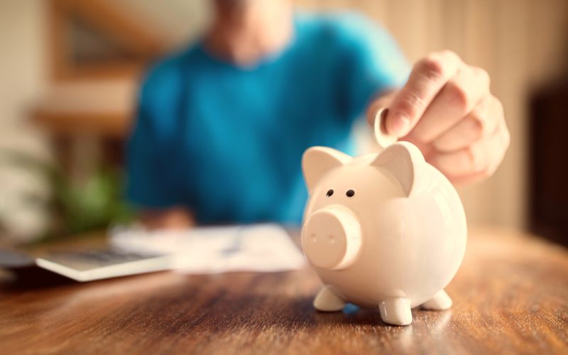 person-saving-putting-money-in-piggy-bank